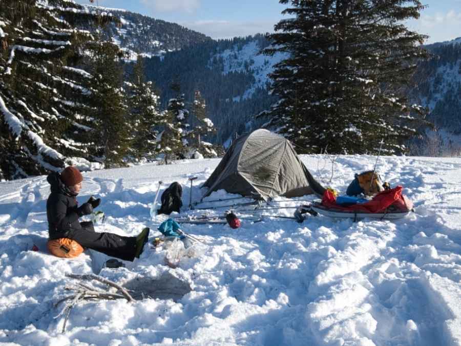 petit déjeuner devant la tente en hiver sur fond de sapins enneigés