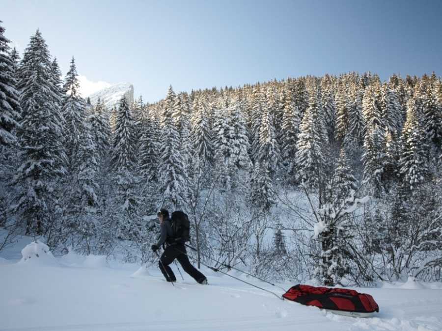 personne tirant une pulka traineau dans un paysage enneigé pour un bivouac